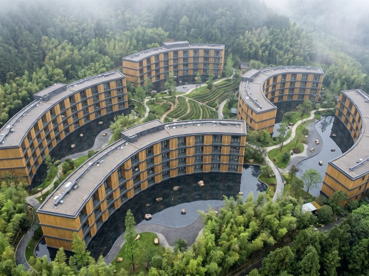 A resort around water in a forested valley, seen from above