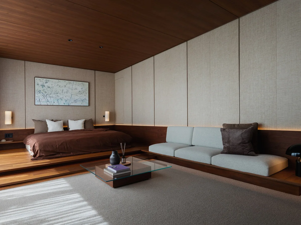 Nanpeidai bedroom on a raised walnut platform, timber ceiling and upholstered walls